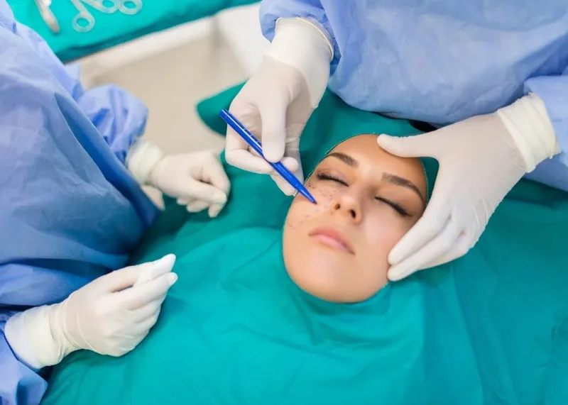 Surgeon examining the nose and eye area of a patient before facial surgery in Istanbul