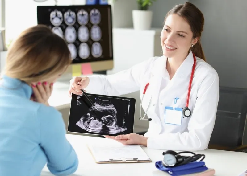An embryologist performing an IVF fertilization procedure under a microscope in a laboratory.