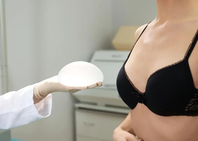 A plastic surgeon makes pre-operative markings on a patient before breast augmentation surgery.