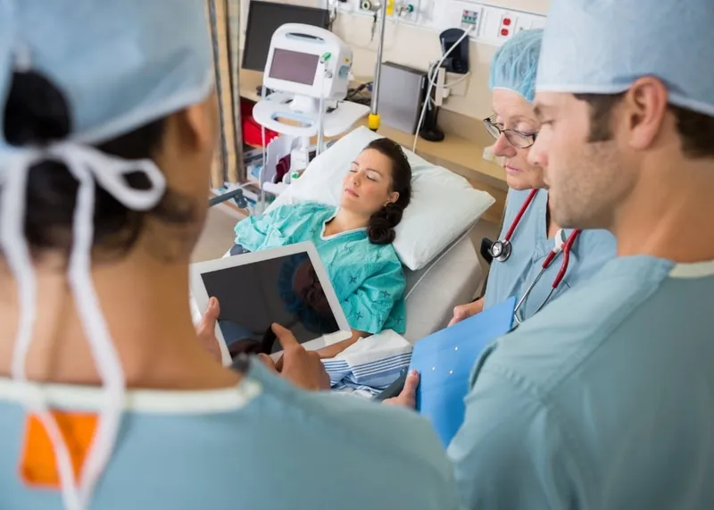 Nurse monitoring a recovering patient's heart rhythm in a cardiac care unit