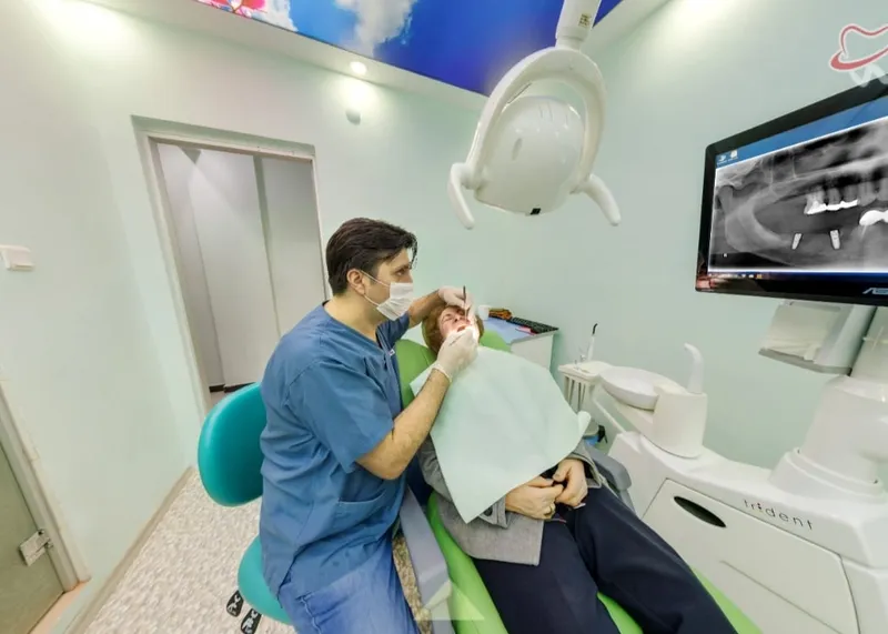 Dentist treating a patient in a modern treatment room at Uzmanlar Dental Clinic in Beşiktaş, Istanbul.